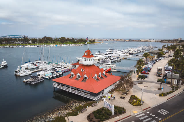 Aerial view of the harbor, the bridge and boats at Coronado Beach, with people walking.