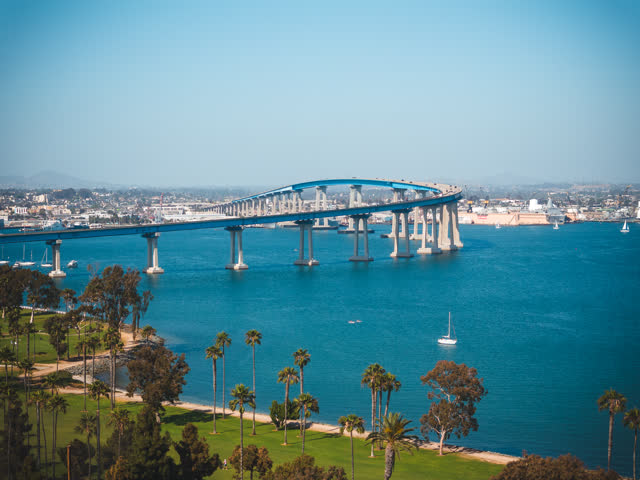 Aerial view of the harbor, the bridge and boats at Coronado Beach, with boats out.