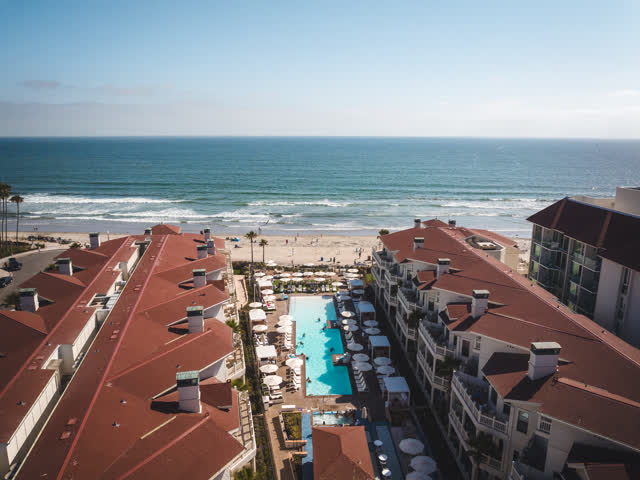 Aerial view of the beach, the surf and palm trees at Coronado Beach.