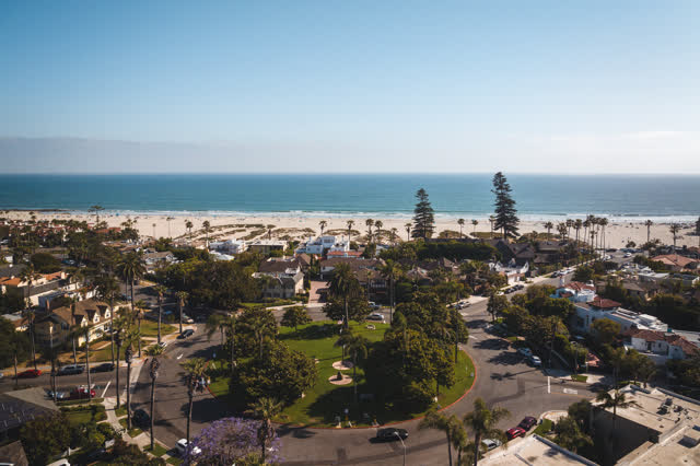 Aerial view of a residential street, palm trees and the ocean in Coronado.