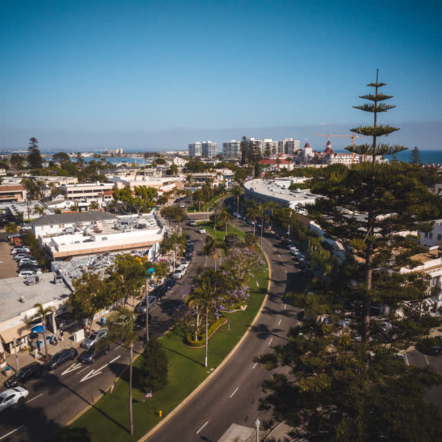 Aerial view of the downtown streets, the skyline and palm trees in Coronado, with people walking.