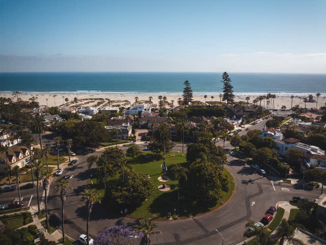 Aerial view of a residential street, palm trees and the ocean in Coronado.