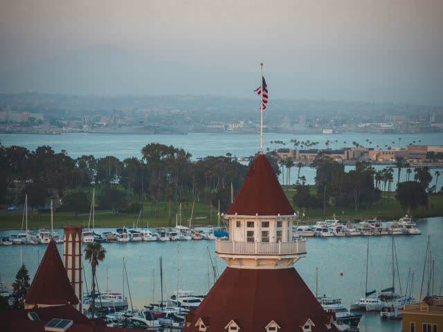 Low aerial view of the harbor, boats and palm trees at Coronado Beach, with boats out.