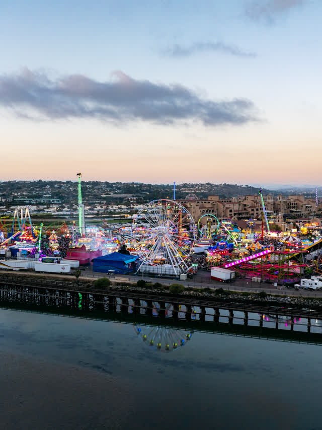 Aerial view of the country inland, traffic and open country in Del Mar, with a crowd gathered.
