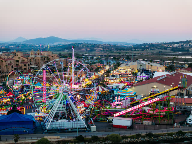 Aerial view of the country inland, the city and traffic in Del Mar, with a crowd gathered.
