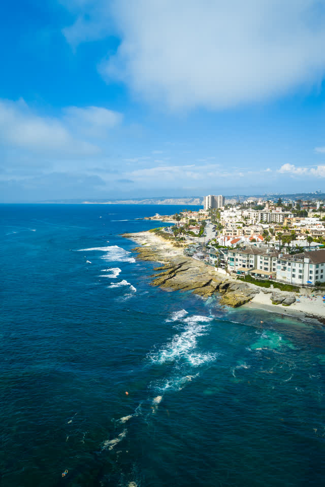 Aerial view of the beach, the ocean and homes at La Jolla Cove.