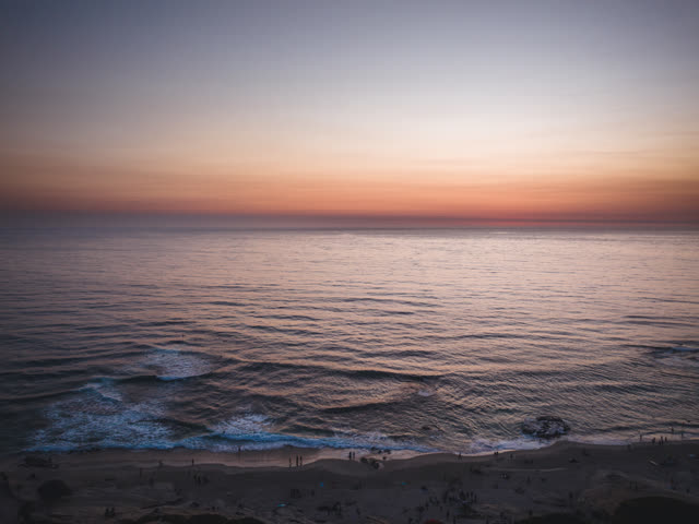 Aerial view of the beach, the surf and the ocean at Windansea, with people walking.