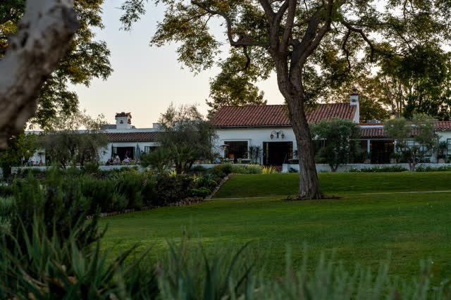 A residential street, palm trees and homes at Covenant, with a crowd gathered.
