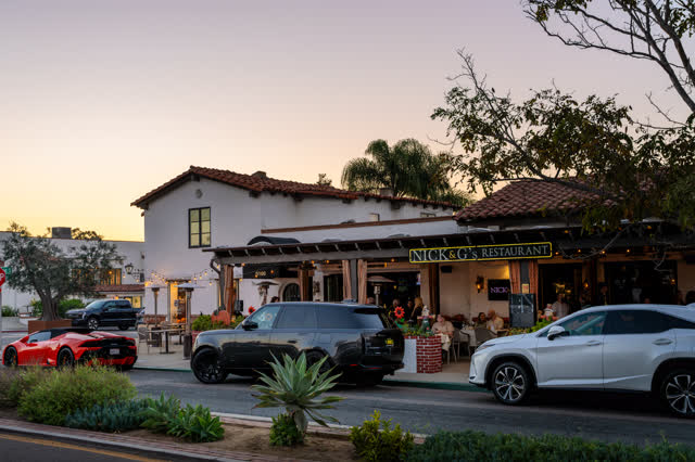 The downtown streets, palm trees and the buildings at Covenant, with people eating outside.