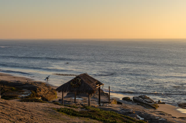 Elevated view of the beach, the surf and the ocean at Windansea, with surfers out.
