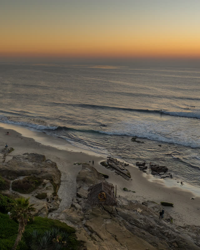 Aerial view of the beach, the surf and the ocean at Windansea, with surfers out.