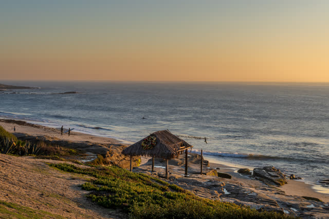 Elevated view of the beach, the surf and the ocean at Windansea, with people walking.