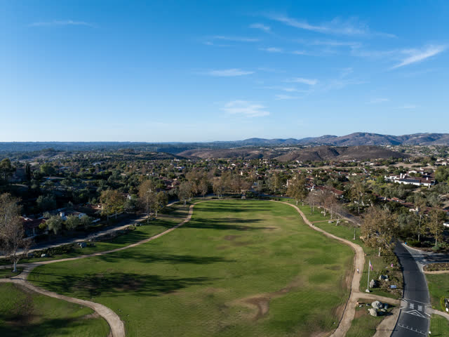 Aerial view of a residential street, homes and open country in Santaluz.