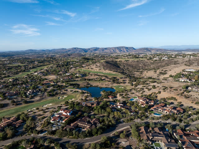 Aerial view of a residential street, homes and open country in Santaluz.