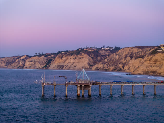 Low aerial view of the beach, the pier and the ocean at La Jolla Shores.