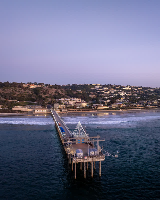 Aerial view of the beach, the surf and the pier at La Jolla Shores.