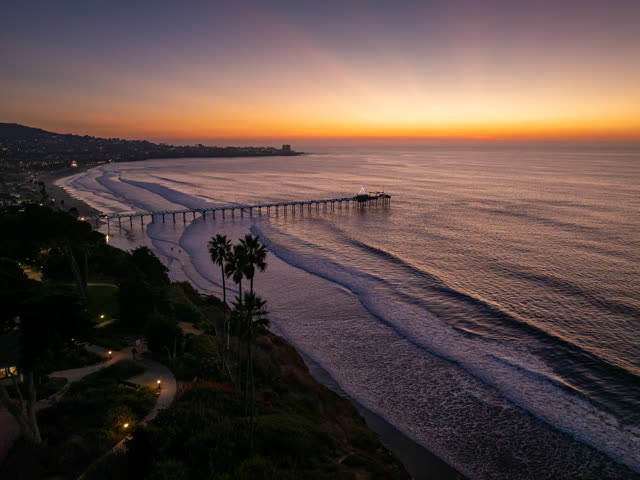 Aerial view of the cliffs, the surf and the pier at La Jolla Shores.