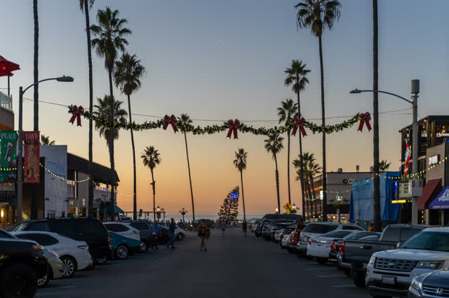 The downtown streets, palm trees and the buildings in Ocean Beach, with people walking.