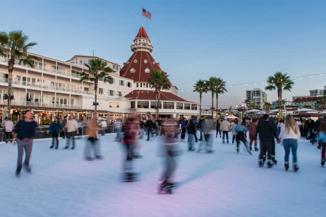 The downtown streets, palm trees and the buildings at Coronado Beach, with a crowd gathered.