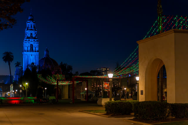 A park, palm trees and the buildings in Balboa Park, with people walking.