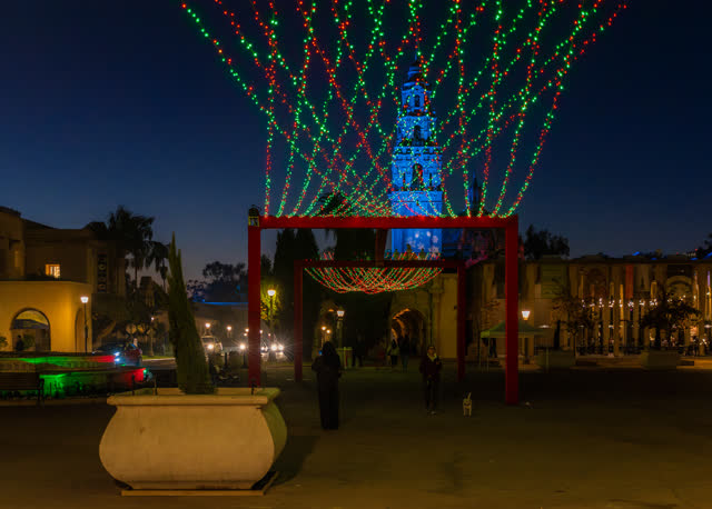 A park, palm trees and the buildings in Balboa Park, with people walking.