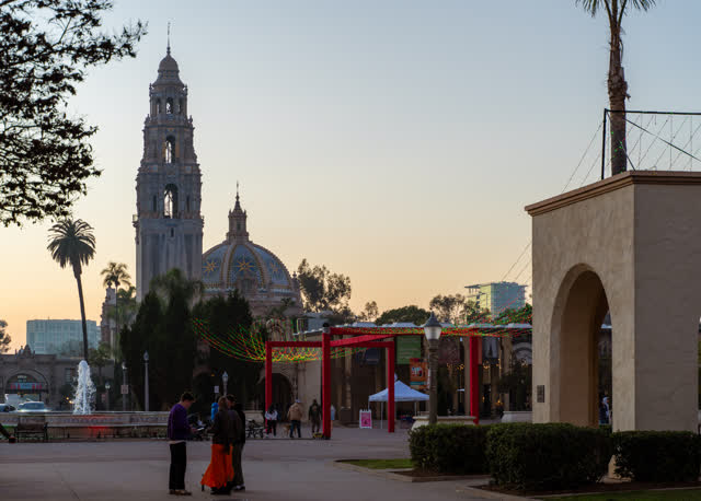 A park, palm trees and the buildings in Balboa Park, with people walking.
