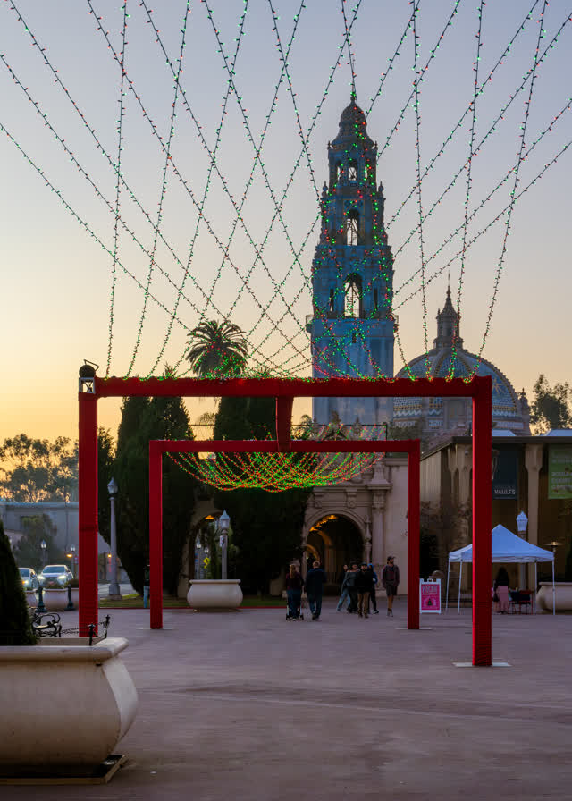 A park, palm trees and the buildings in Balboa Park, with people walking.