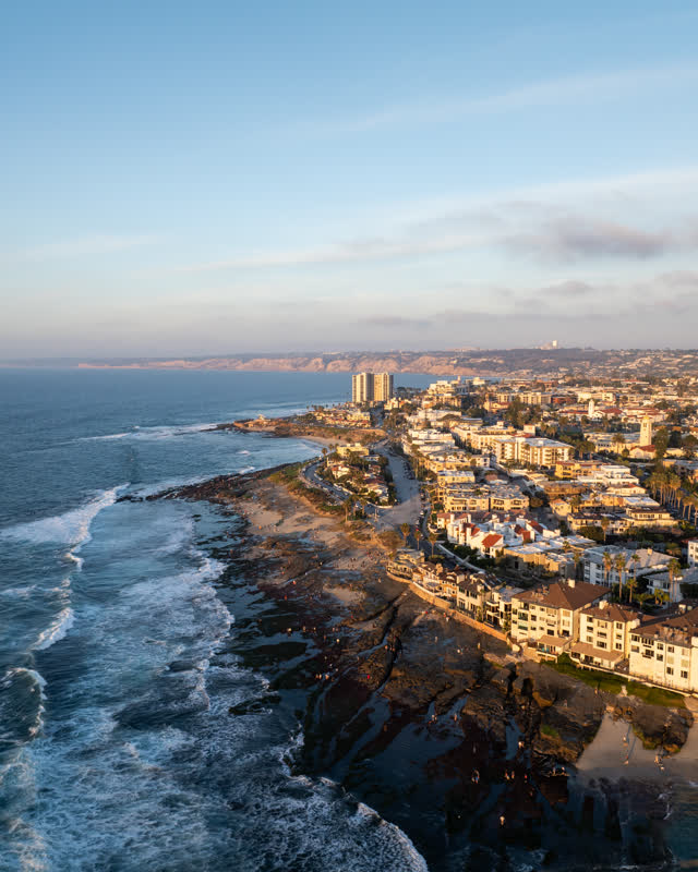 Aerial view of the beach, the surf and palm trees at La Jolla Cove.
