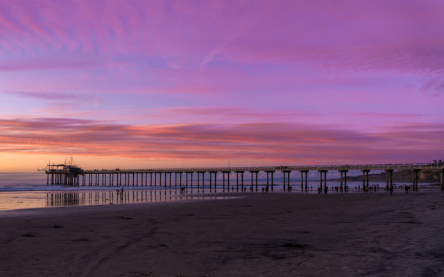 The beach, the pier and the ocean at La Jolla Shores, with people walking.