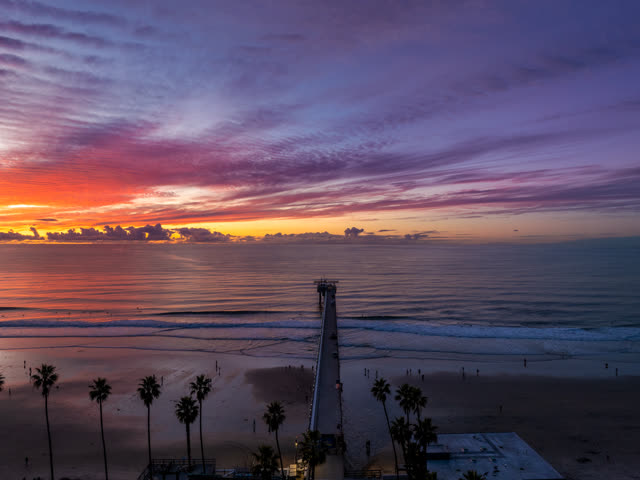 Aerial view of the beach, the surf and the pier at La Jolla Shores, with people walking.