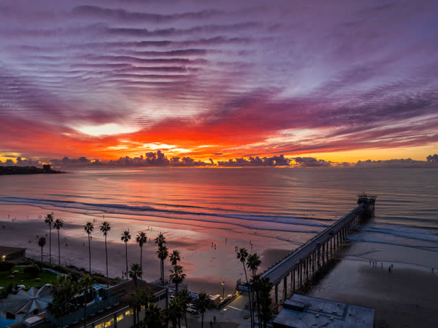 Overhead drone photo of Scripps Pier during sunset in La Jolla Shores San Diego California highlighting ocean texture and glowing horizon | Drone Photo – 6