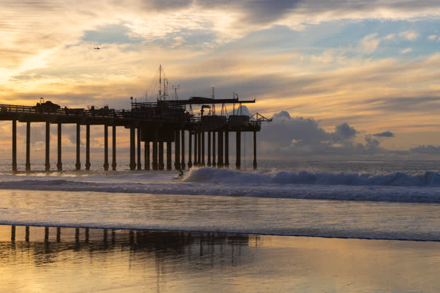 The beach, the surf and the pier at La Jolla Shores, with surfers out.