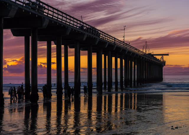 The beach, the pier and the ocean at La Jolla Shores, with people walking.