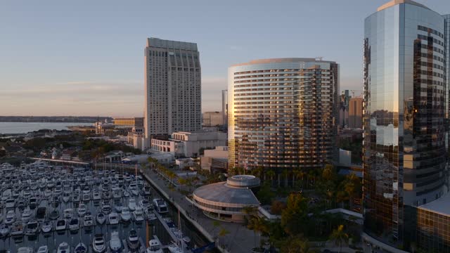 Low aerial view of the downtown streets, the skyline and boats at Marina.