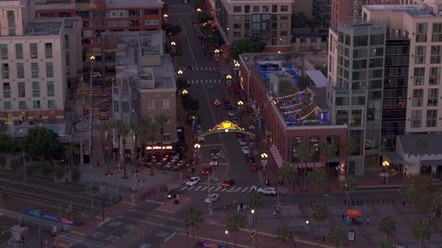 Low aerial view of the downtown streets, palm trees and homes at Gaslamp, with people walking.