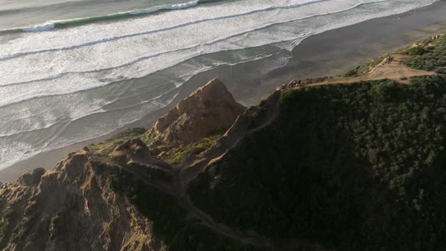 Aerial view of the cliffs, the surf and the ocean at Black’s Beach.