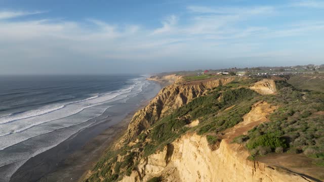 Aerial view of the cliffs, the surf and the ocean at Black’s Beach.