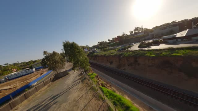 Low aerial view of a residential street, homes and traffic at Leucadia.
