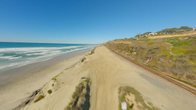 Low aerial view of the beach, the surf and the ocean at Torrey Pines.
