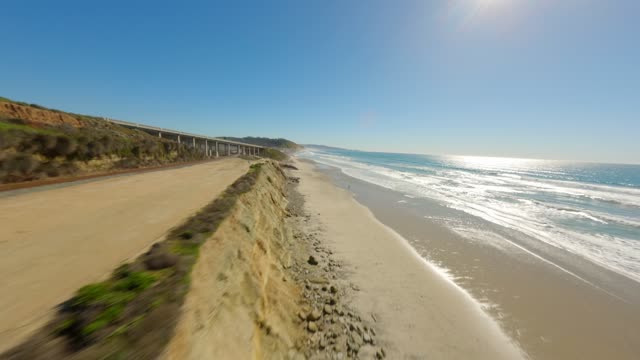 Low aerial view of the beach, the surf and the ocean at Torrey Pines.