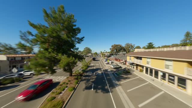 Low aerial view of the downtown streets, the buildings and the city in Del Mar, with people walking.