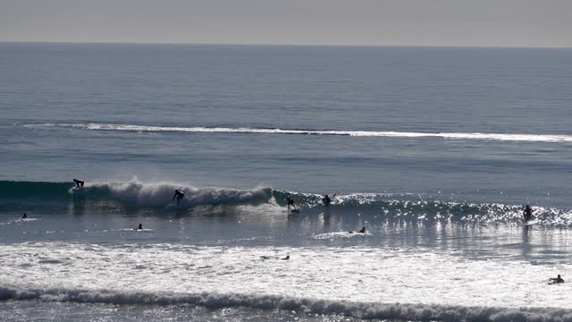 Elevated view of the beach, the surf and the ocean at Leucadia, with surfers out.