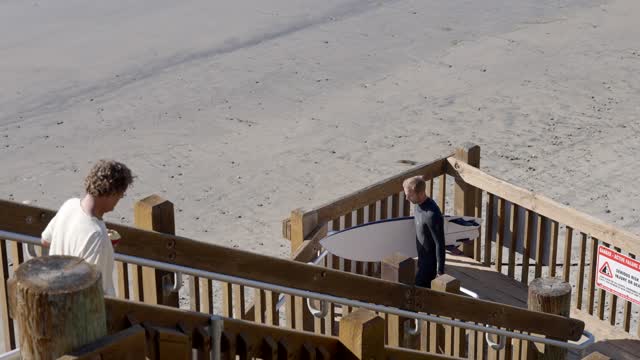 Elevated view of the beach and the water at Leucadia, with people walking.