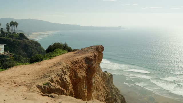 Elevated view of the cliffs, the surf and the pier at Black’s Beach.