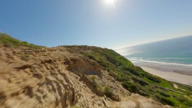 Low aerial view of the cliffs, the ocean and the beach at Black’s Beach.