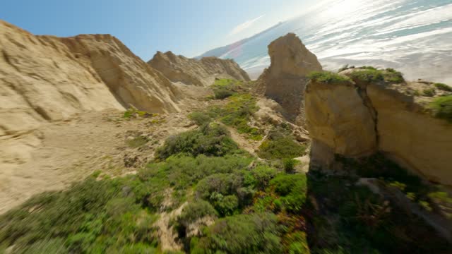 Low aerial view of the cliffs, the ocean and open country at Black’s Beach.
