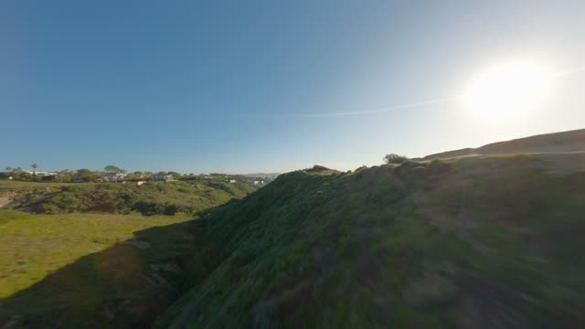 Low aerial view of the cliffs, homes and open country at Black’s Beach.