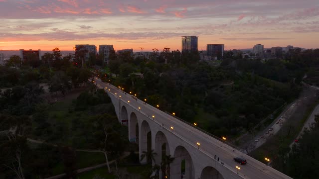 Low aerial view of a park, the bridge and the skyline at Bankers Hill, with people walking.