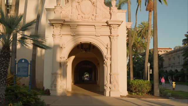 A park, palm trees and the buildings in Balboa Park, with people walking.