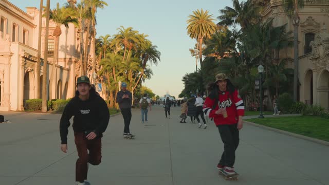 A park, palm trees and the buildings in Balboa Park, with people walking.
